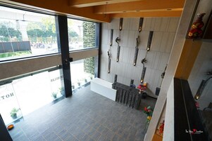 Un'area reception di un hotel dal design moderno, con una scrivania, una parete decorata e vista sulla strada.