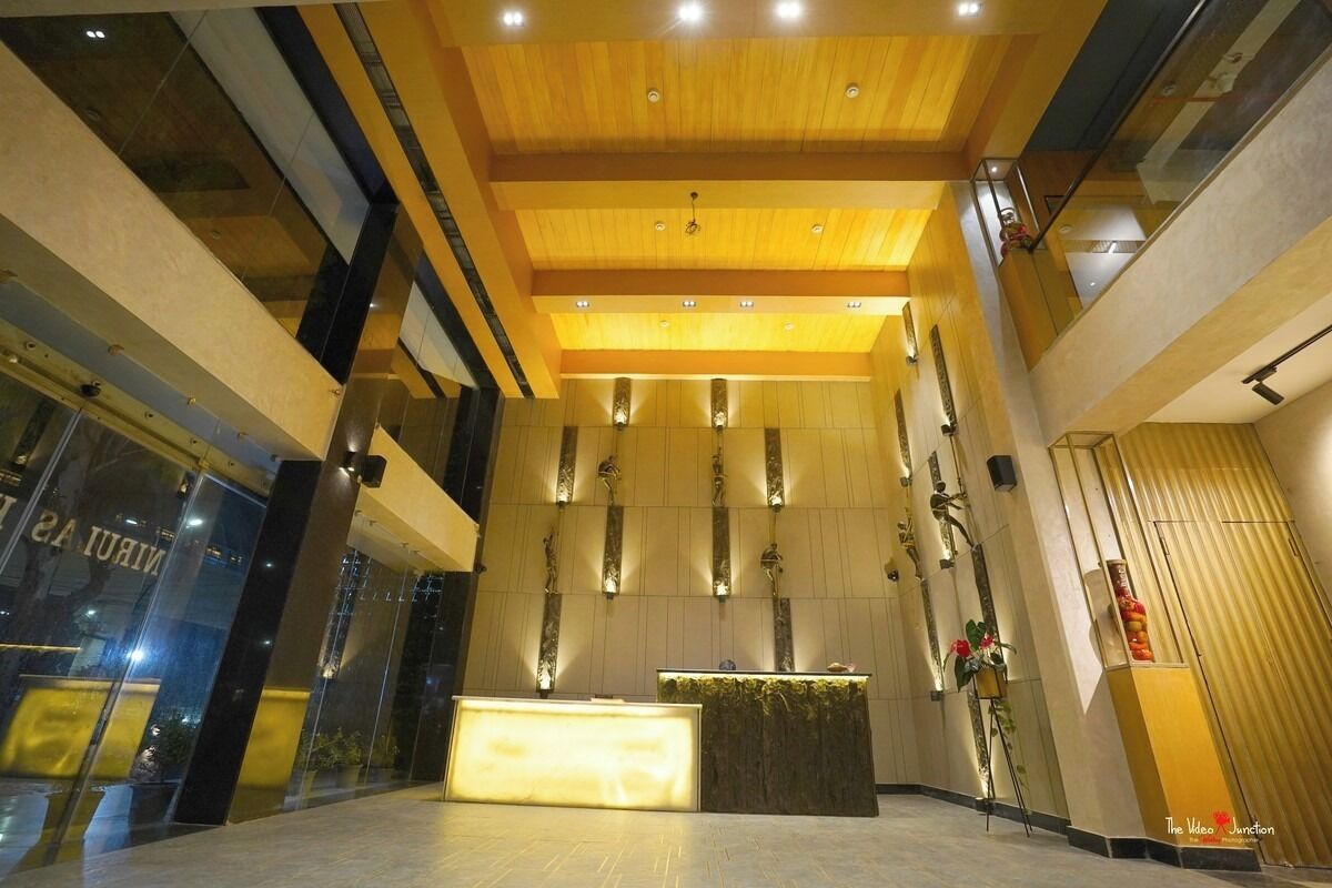Un vestíbulo moderno con un mostrador de recepción, techo de madera y grandes ventanales.