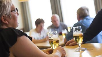 A group of people sitting at a table with glasses of beer.