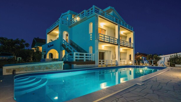 A two-story building with a swimming pool in front.