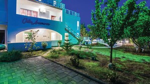 A hotel with a blue facade, a visible entrance, and a staircase leading to the upper floor.