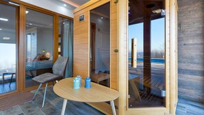 Une pièce moderne avec un meuble en bois, une table ronde sur laquelle reposent deux récipients bleus, et une chaise.