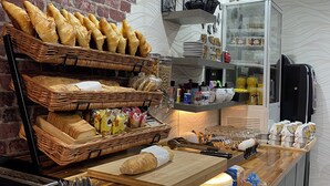 A breakfast bar with bread, pastries, and utensils. - Savoie Hotel (Saint-Julien-en-Genevois)
