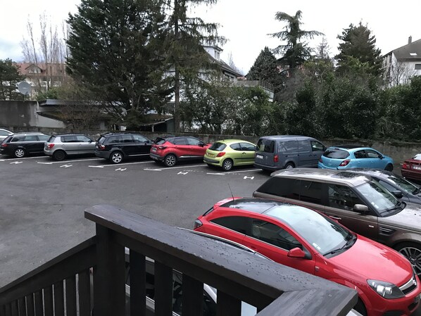 A parking lot with various cars parked, surrounded by trees and buildings.