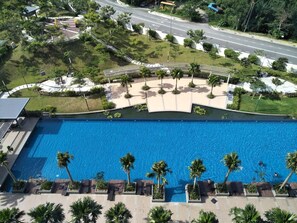 Una piscina al aire libre, sombrillas, sillones reclinables de piscina