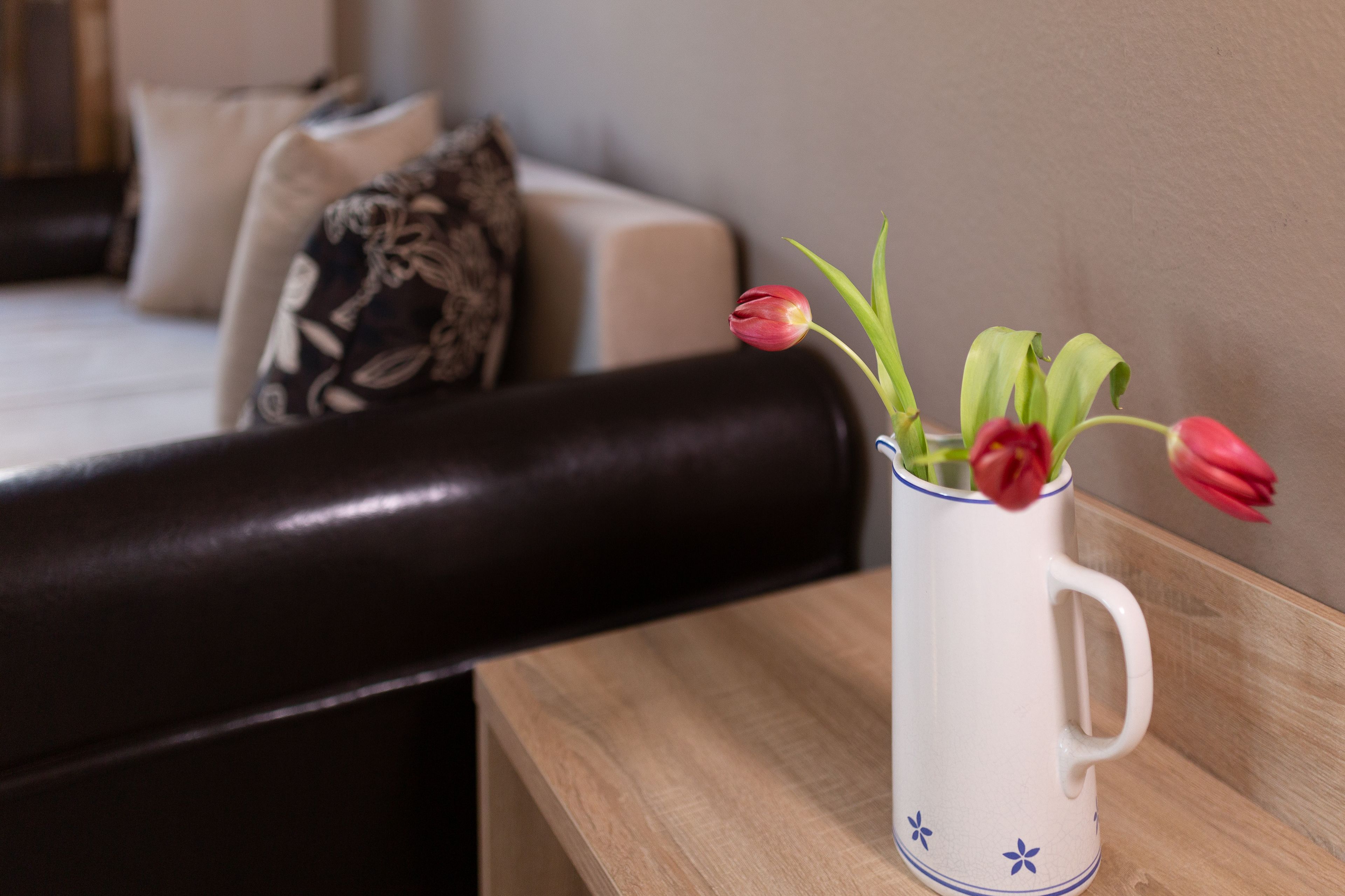 Un jarrón blanco con motivos florales azules sobre una mesa de madera.