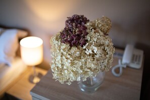 Un vase avec une composition florale sur une table de chevet.