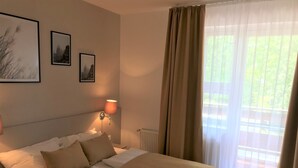 Una habitación de hotel con una cama, una mesita de noche, una lámpara y dos cuadros en la pared.