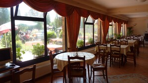 Un restaurante con ventanas amplias, mesas y sillas.