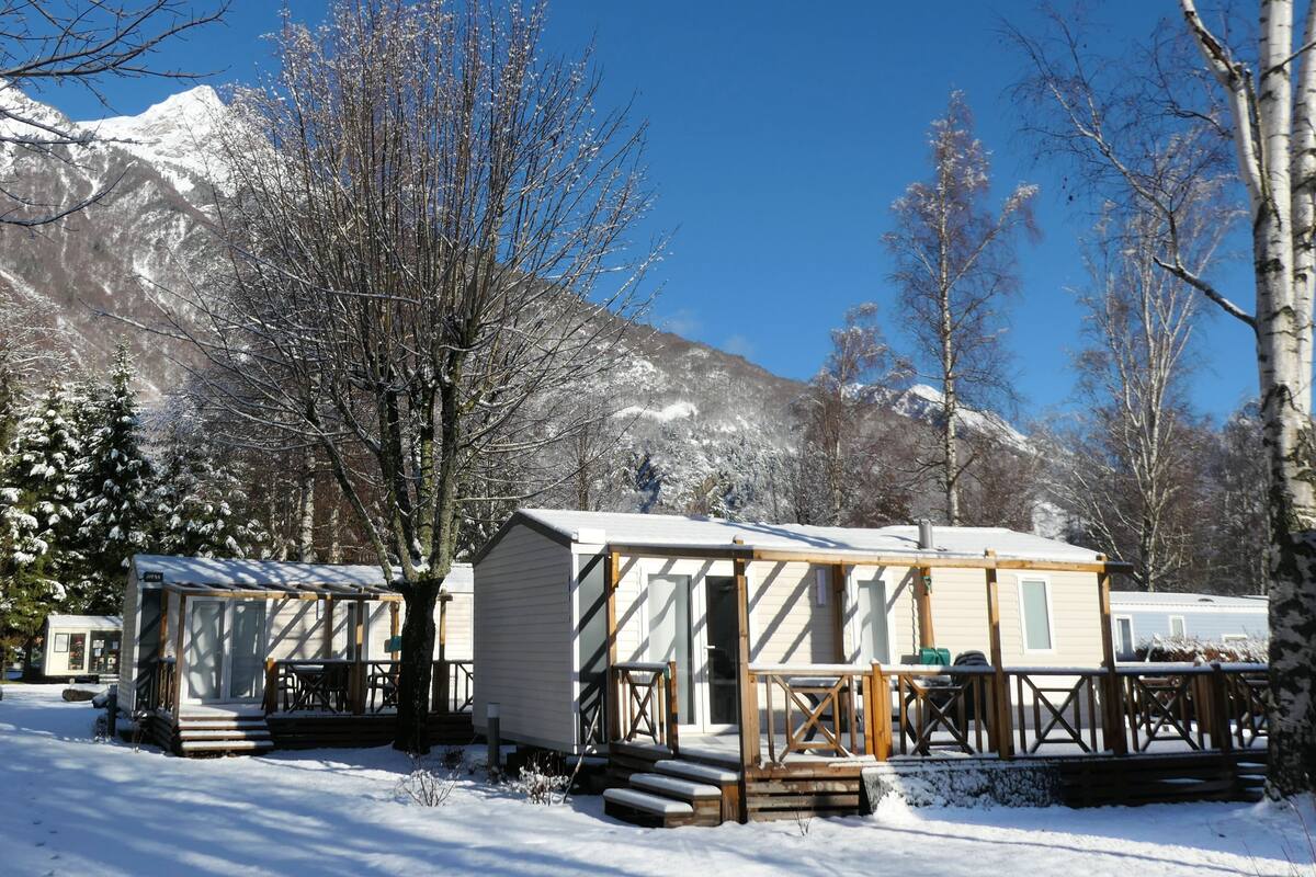 A snow-covered outdoor area with cabins and a mountain backdrop.