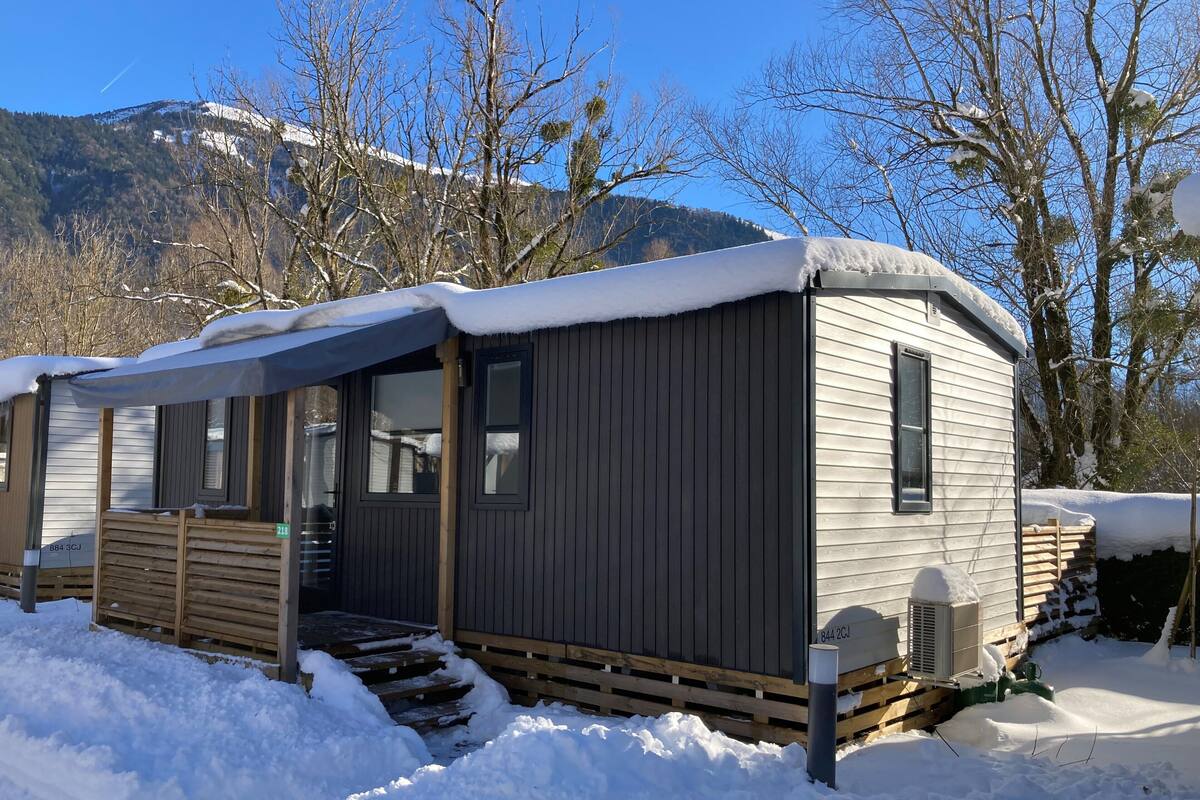 A mobile home with a covered porch, a small front porch, and a window.
