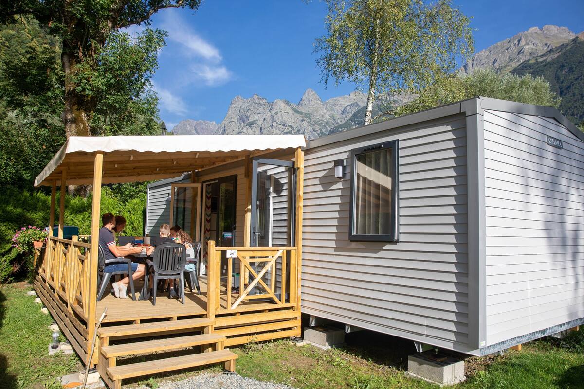 A small cabin with a wooden deck and a covered patio area.