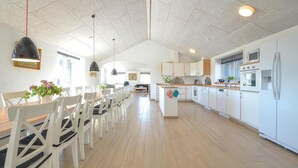 A spacious kitchen with white cabinets, a central island, and modern appliances.