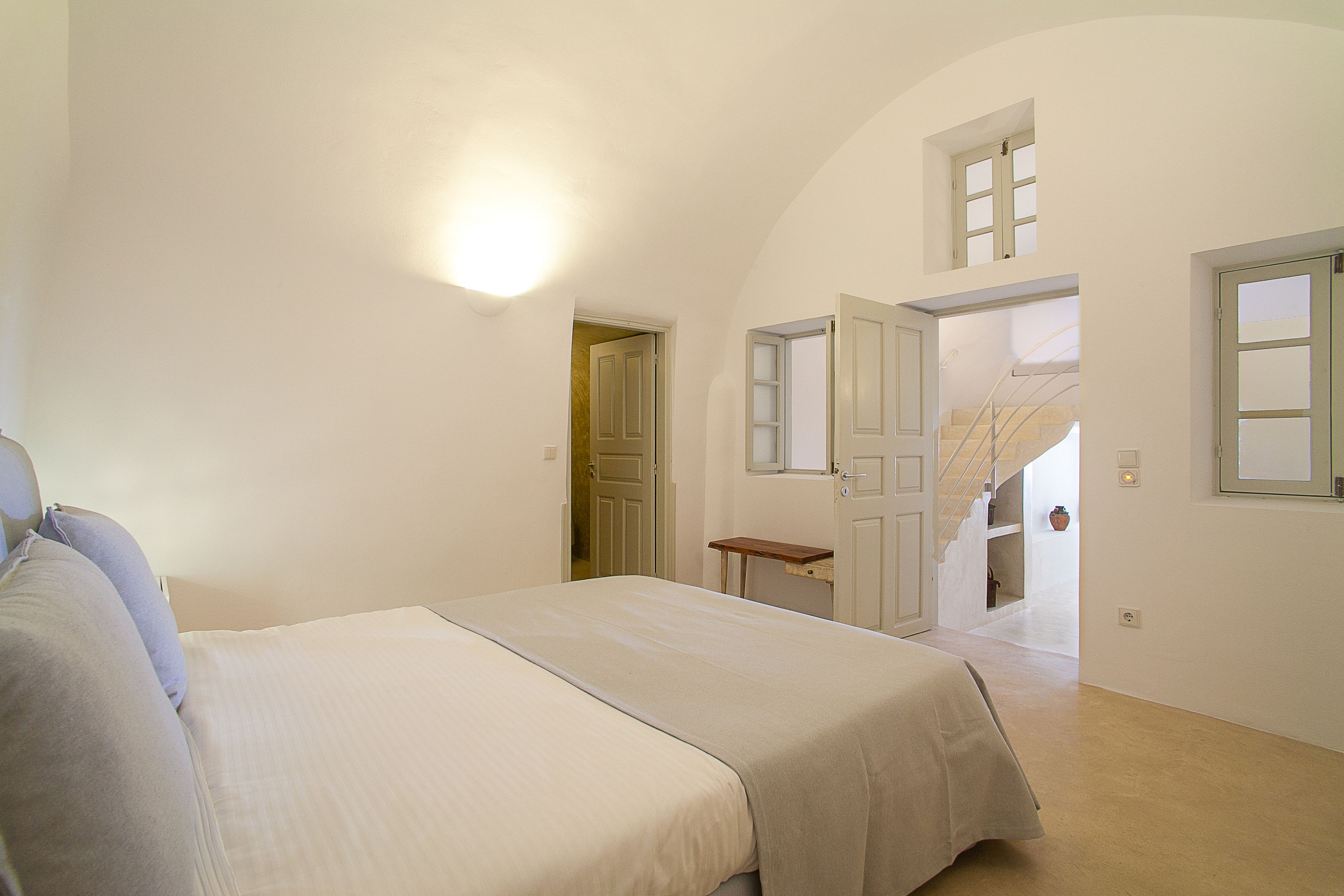 Une chambre à coucher avec un grand lit, une petite table et un escalier menant à un niveau supérieur.