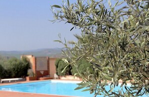 Een seizoensgebonden buitenzwembad, parasols voor strand/zwembad