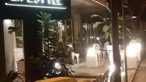 Un letrero de hotel con la inscripción iluminada "REX HOTEL LIFESTYLE" en la noche.