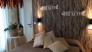 Un dormitorio con pared de madera, dos luces fijadas a la pared y una cama con muchas almohadas.