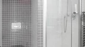 A modern bathroom with a toilet, a shower with a glass door, and grey tiled walls.