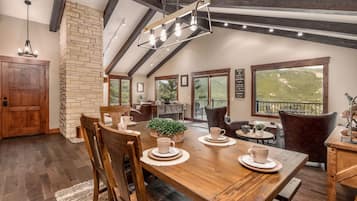 A dining area with a wooden table, chairs, and a hanging light fixture.