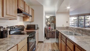 A compact kitchen with wooden cabinets, a stove, and a sink. - 112 Marina Place 2 Bedroom Condo by RedAwning (Dillon)