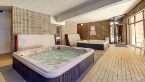 A spa area with two hot tubs, a wooden wall, and a tiled floor. - 112 Marina Place 2 Bedroom Condo by RedAwning (Dillon)