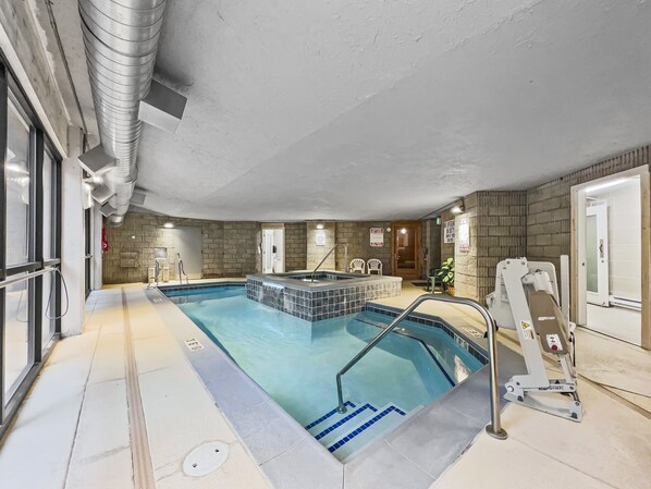 Una piscina con vestuario, una silla de salvavidas y un área de spa.