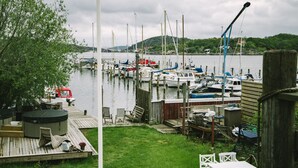 A dock with boats, a hot tub, and outdoor furniture. - Brännö Varv Bed & Breakfast (Branno)