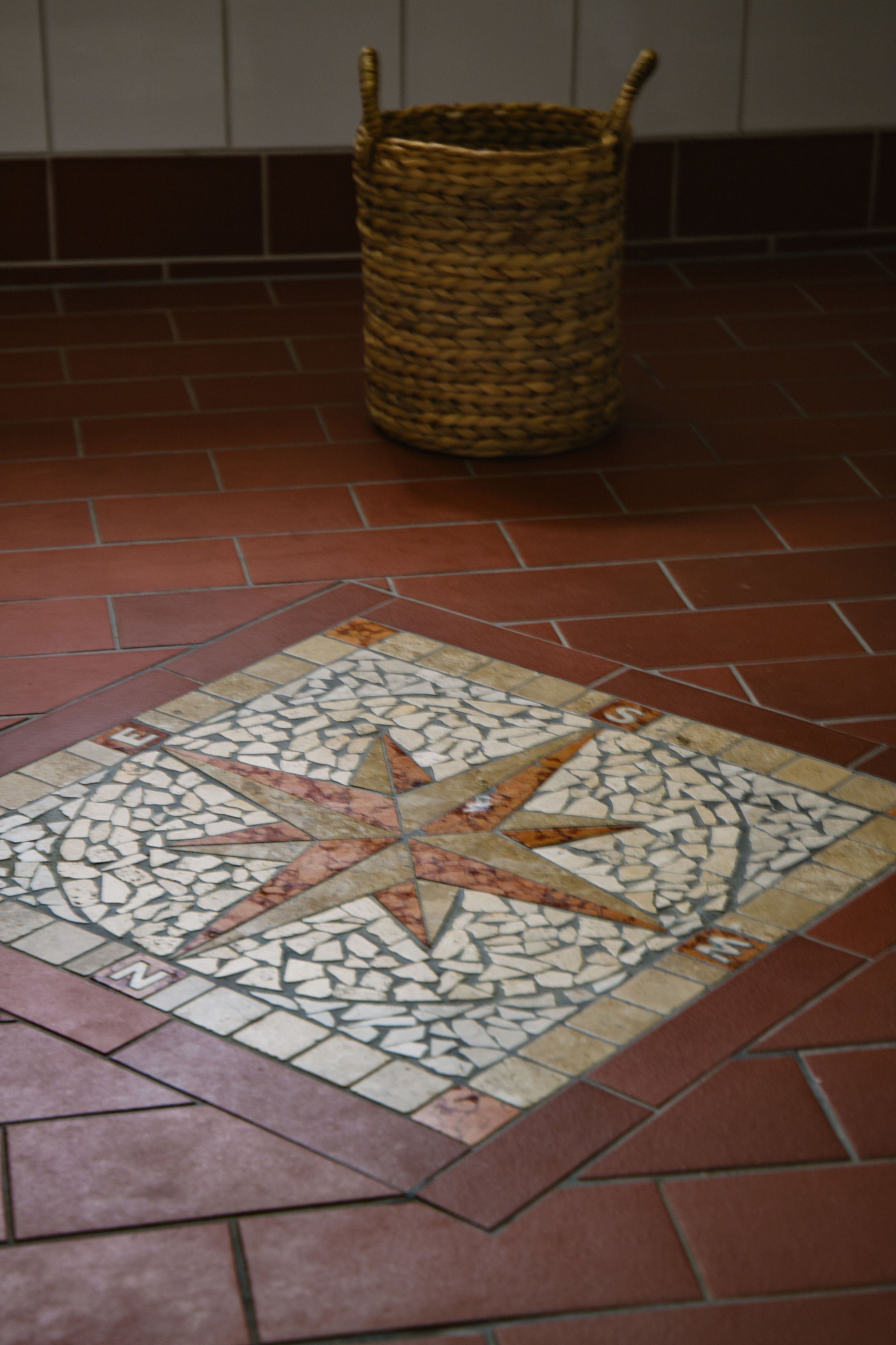 A tiled floor with a star pattern and a woven basket.
