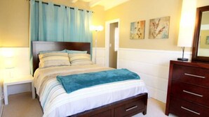 Ein Schlafzimmer mit Bett, Nachttischen, einem Schminktisch und Bildern an der Wand.