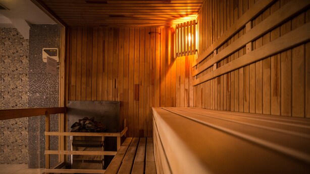 Una sauna de madera con bancos y un revestimiento de baldosas.