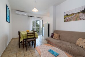 Un coin repas avec une table et des chaises, un canapé et un tableau au mur.