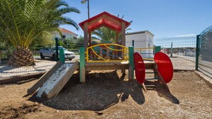 Un’area giochi con uno scivolo, altalene e una struttura per arrampicarsi.