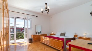 Un'ampia stanza con un grande letto, un tavolo da pranzo in legno e un lampadario.