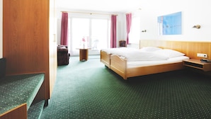 Une chambre d’hôtel équipée d’un lit, d’un bureau, d’une chaise, d’une armoire et offrant une vue sur l’extérieur.