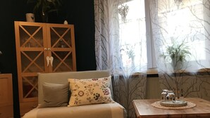 Un soggiorno accogliente con un divano, un armadio in legno e un tavolino con oggetti decorativi.