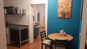 Una cucina compatta con fornelli, pensili e un'area pranzo con tavolo e sedie.