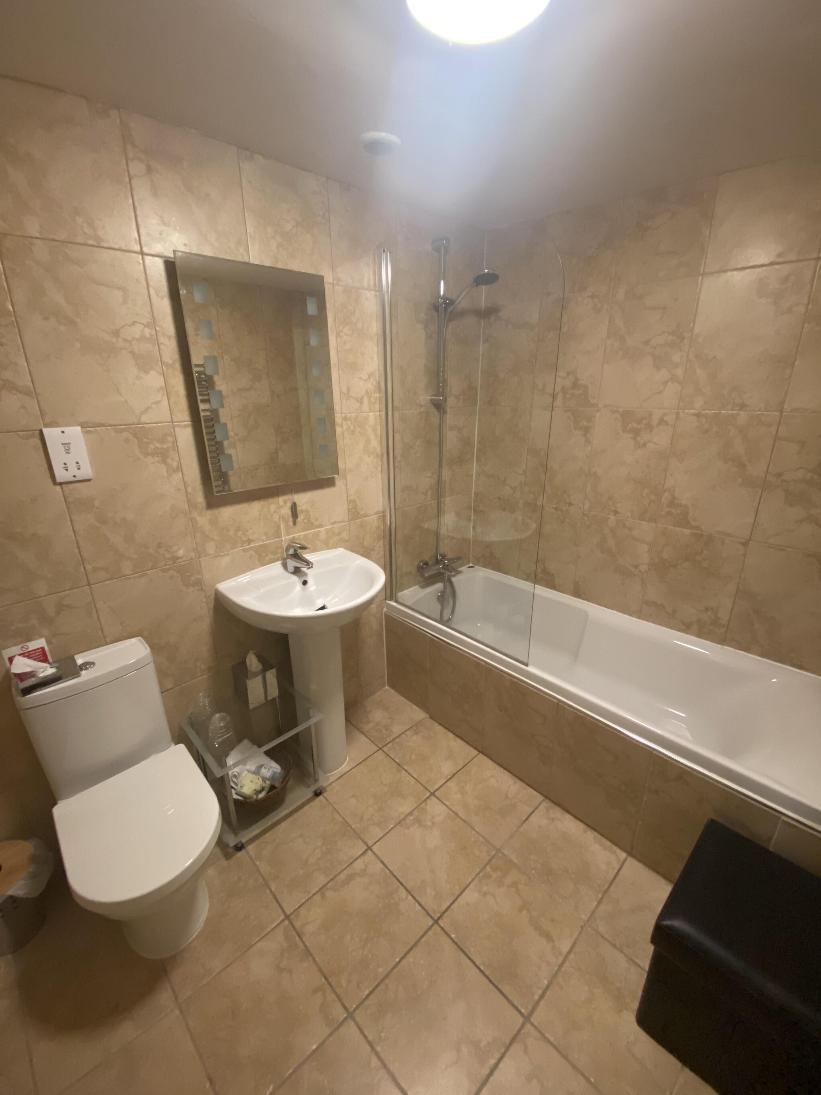 Une salle de bain avec des toilettes, un lavabo et une baignoire.