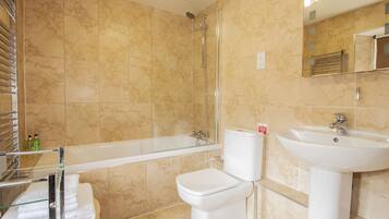 Un baño con bañera, inodoro y lavabo.