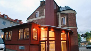 A red brick building with a corner entrance, large windows, and a sign that reads "GO TO SLEEP". - Go To Sleep Arvika - Hostel (Arvika)