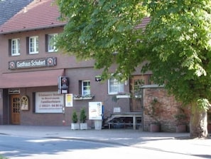 A building with a sign that reads 'Gasthaus Schubert' and a visible entrance.