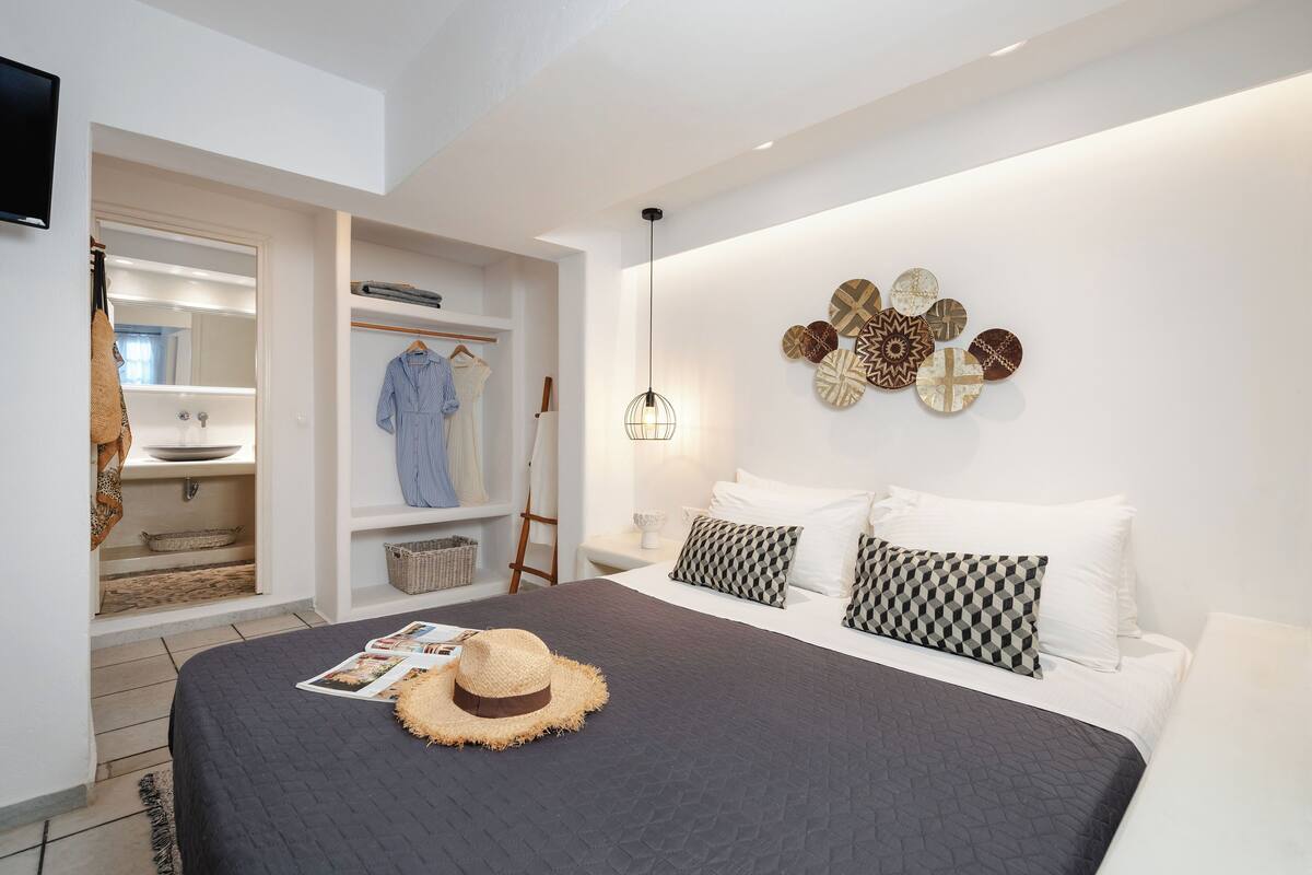 A bedroom with a bed, bedside table, and a wall with decorative plates.