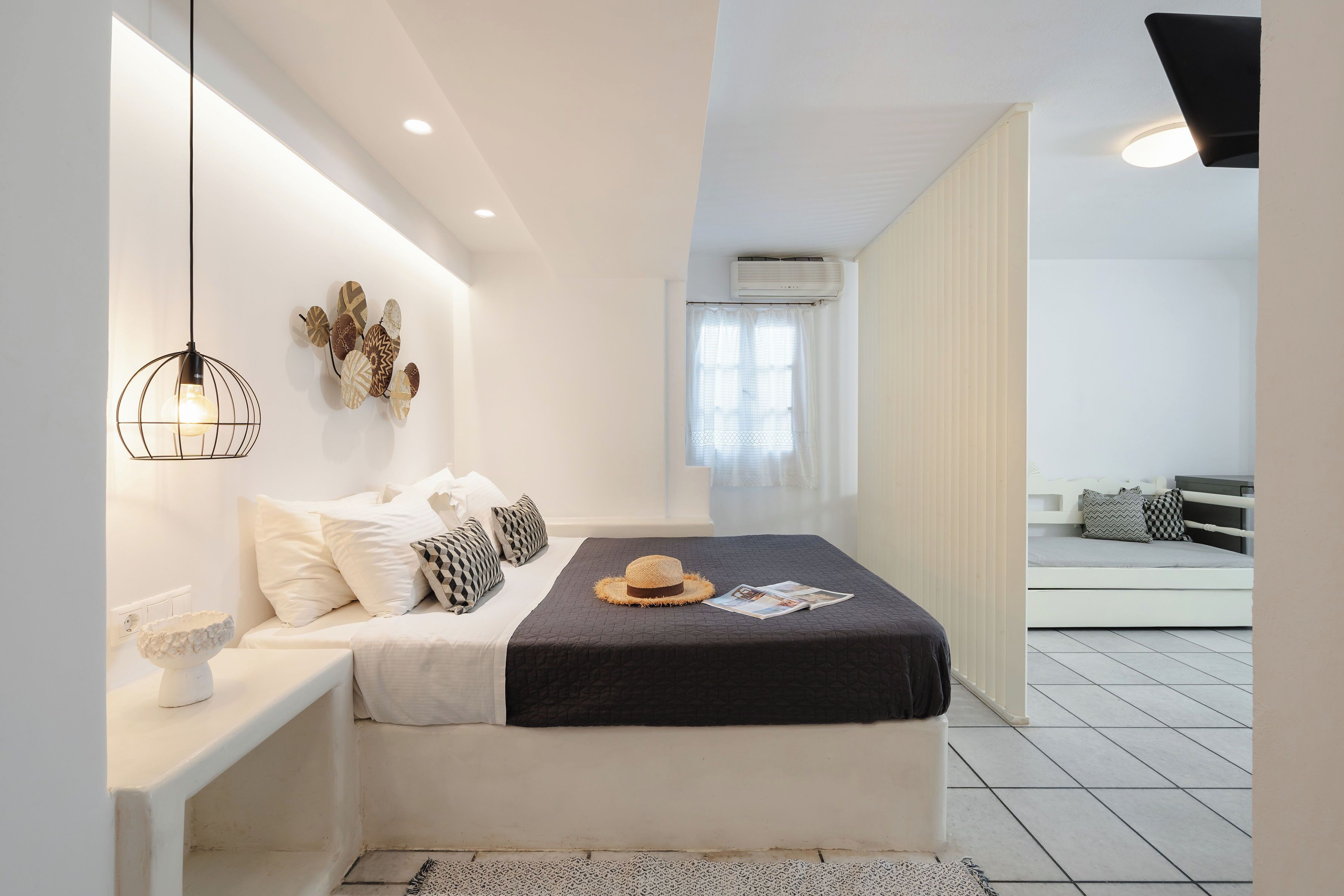 A modern bedroom with a bed, bedside table, and a decorative wall piece.