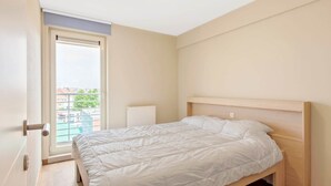 Una camera da letto con un letto, una finestra e un termosifone.