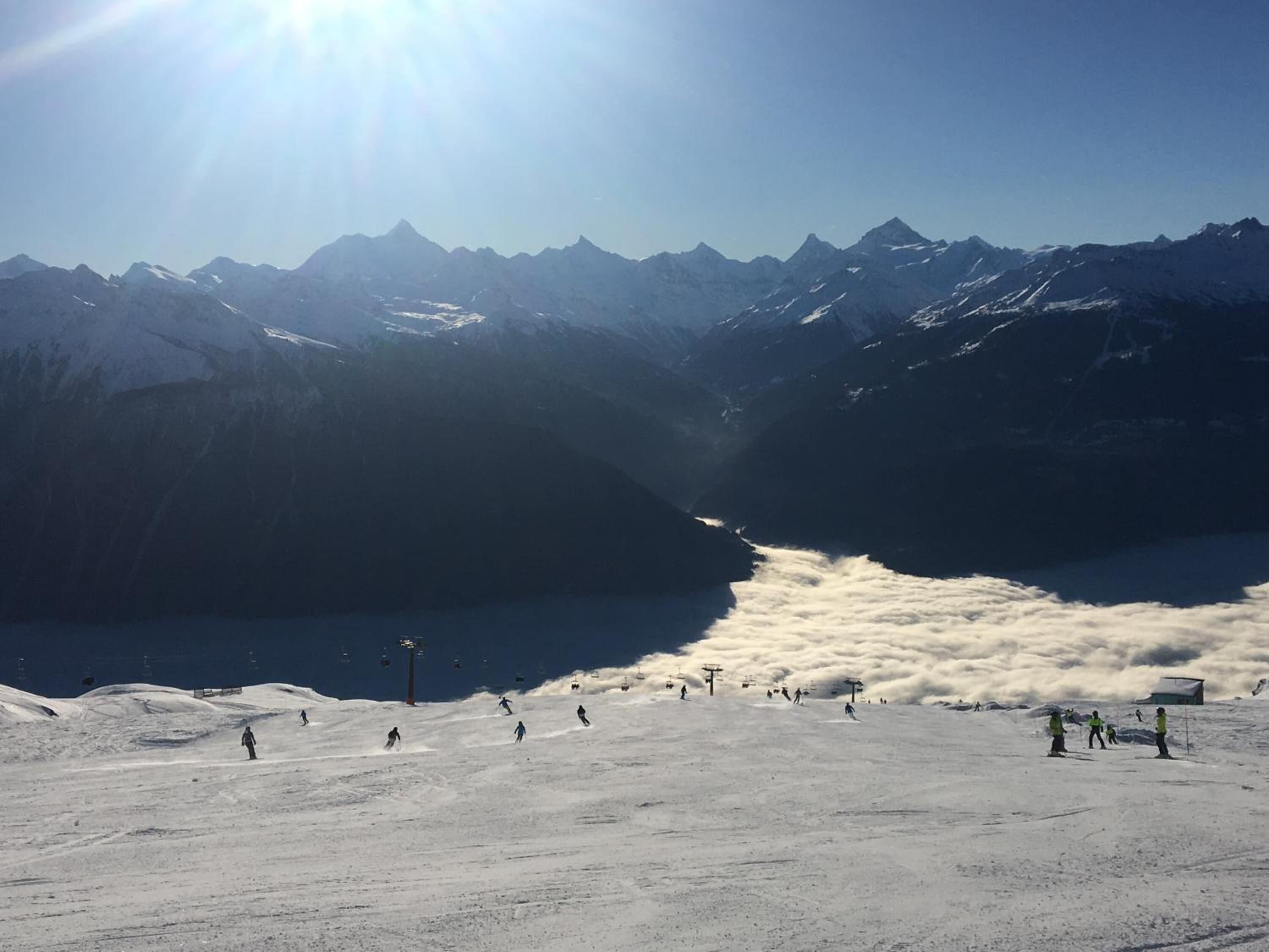 A snow-covered mountain landscape with a ski slope and a clear sky.