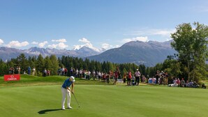 A golf course with a mountainous backdrop, a crowd of spectators, and the Omega logo. - B&B La Forge de Diogne (Crans-Montana)