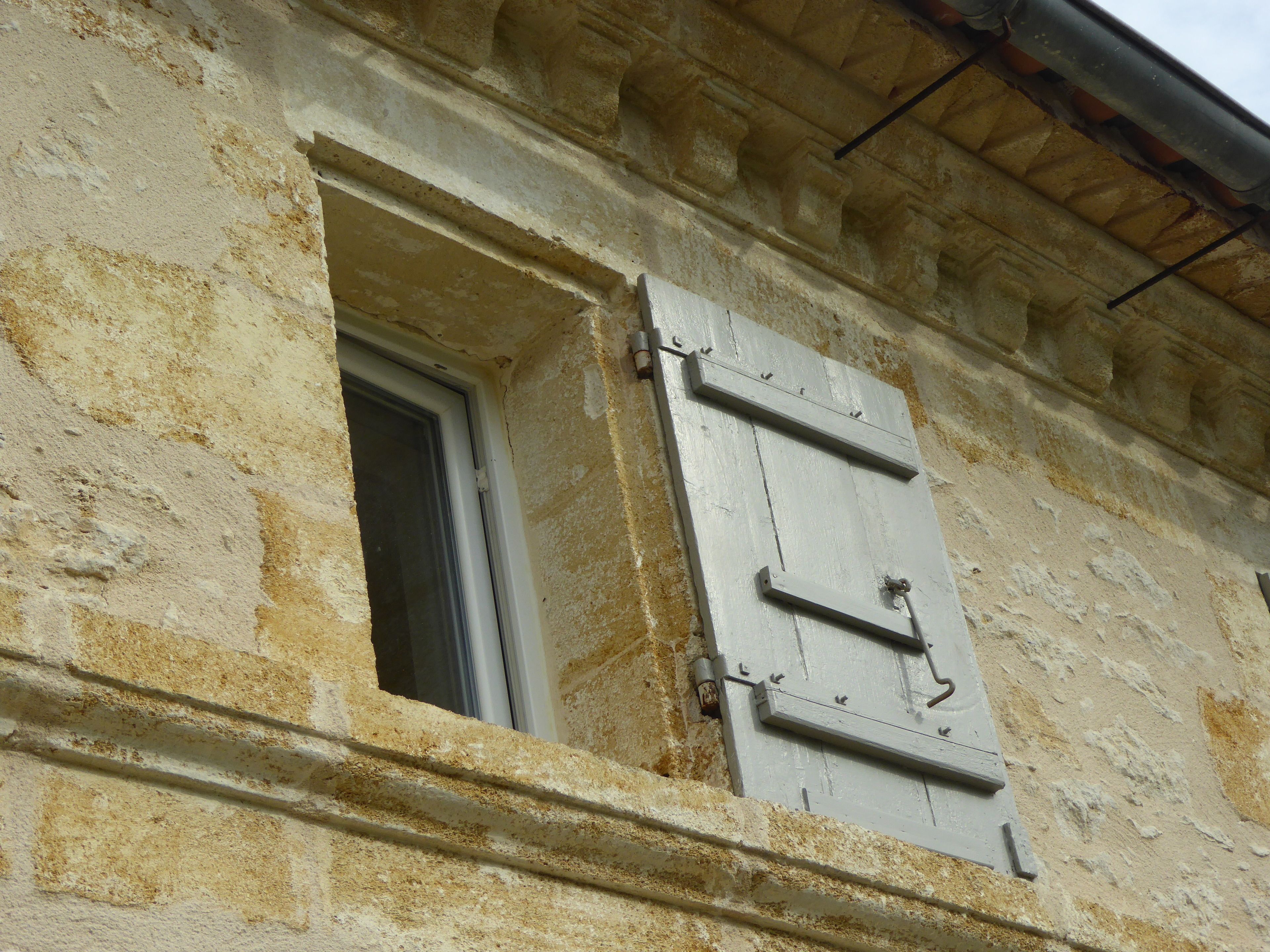 A building with a window and a shutter.