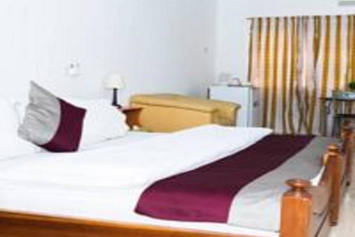 Ein Hotelzimmer mit Bett, Schreibtisch und Stuhl.