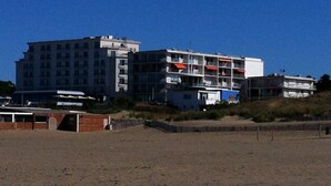 Ein mehrstöckiges Hotel mit Balkonen in Strandnähe.