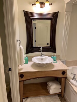 Ein Badezimmer mit einem weißen Waschbecken, einem großen Spiegel und einer Badewanne.