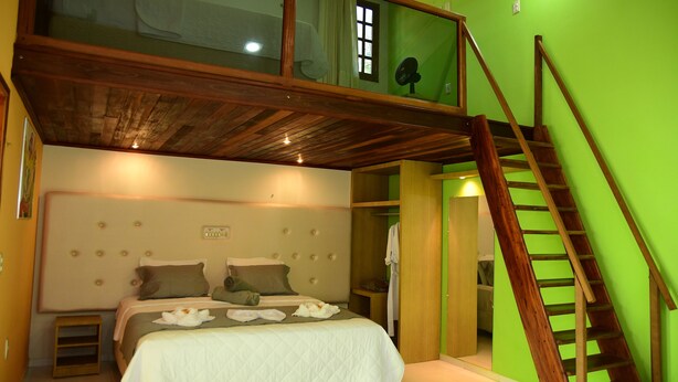 A bedroom with a loft bed, a wooden staircase, and a green wall. - Hotel Serrano (Martins)